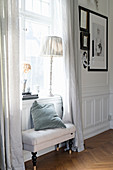 Upholstered bench below window in panelled wall
