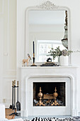 Classic mantelpiece and large mirror above open fireplace