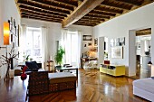 Rustic wood-beamed ceiling, herringbone parquet floor and open doorways in renovated period apartment