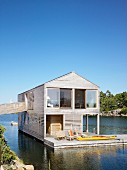 Two-storey wooden house with terrace floating on lake