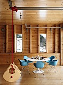 Classic dining set and suspended designer swing in wooden house