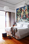 Double bed under large-format painting in the bedroom