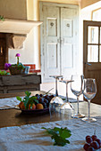 Wine glasses and fruit on table in Mediterranean country-house kitchen