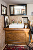 Aufsatzwaschbecken auf alten Holztisch im Bad mit niedriger Decke