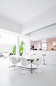 Dining area and open-plan kitchen in white, architect-designed house