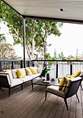 Elegante Outdoormöbel auf überdachter, erhöhter Terrasse mit Holzdeck