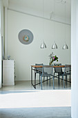 Delicate dining set below sloping ceiling in purist interior