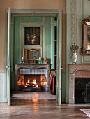 View through open double doors to roaring fire in open fireplace