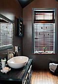 Window with louvre blinds in bathroom in shades of brown