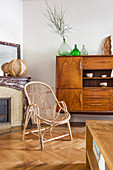 Rattan armchair in front of old cabinet with veneer front