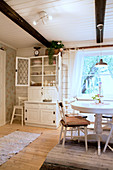 Kitchen dresser with open doors in country-house-style dining room