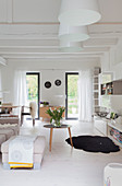 Helles Wohnzimmer mit Balkendecke und weißem Boden