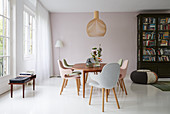 Chairs with pastel upholstery around dining table on white floor
