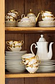 Old gold-rimmed coffee set in cupboard