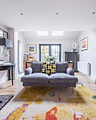 Grey sofa on colourful rug