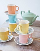 Pastel retro tea set stacked on rustic wooden table