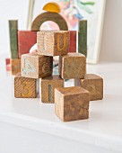 Letters and numbers on worn, stacked wooden building blocks