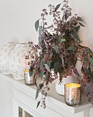 White mantelpiece decorated with candlelight and twigs