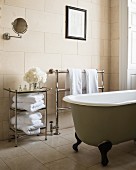 Free-standing bath and towel rails in bathroom with tiled walls and floor