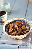 Dried figs in ceramic bowl on vintage wooden table