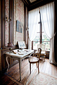 Baroque chair at old desk against classic panelled wall
