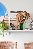 Houseplants, ornaments and table lamps on wall-mounted shelf