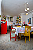 Offene Küche in Altbauwohnung mit bunten Möbeln und Esstisch