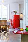 Red fridge and neon deer silhouette in kitchen of period apartment