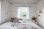 Wintry decorations in small bedroom decorated entirely in white