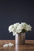 Strauß mit weißen Rosen in einer alten Silberdose