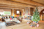 Christmas tree and fire in fireplace in log cabin