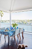 A table laid in blue and white on a summery terrace