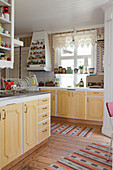 Alte Küche mit gelben Kassettenfronten im skandinavischen Landhausstil