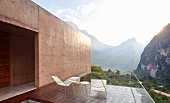 Sun shining behind mountains seen from balcony of architect-designed house