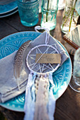 Small dreamcatcher and name tag on blue plate