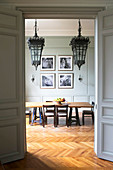 View through open double doors into dining room with antique ceiling lamps