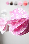 Pink paper garland with white floral pattern