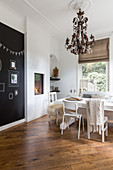 Recessed fireplace, black accent wall and wooden floor in dining room