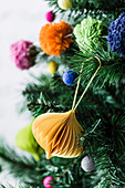 Pleated ornament and colorful pompoms as Christmas tree decorations
