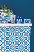 Blue and white Oriental china on shelf mounted on blue wall