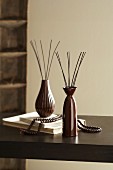 Brown vases with perfume diffusers on table