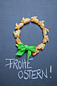 Wreath of pastry bunnies and Easter greeting on chalkboard