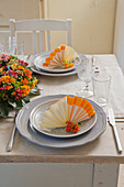 Serviettes folded into two-tone fans on plates
