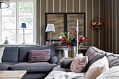 Cosy living room in shades of grey with striped wallpaper
