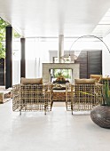 Designer rattan furniture, fireplace and arc lamp in bright interior
