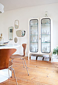 Collection of vases in old glass-fronted cabinet in retro dining room