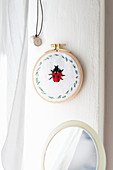 Fabric embroidered with ladybird in embroidery frame