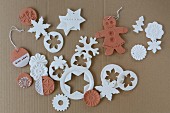 Clay Christmas decorations in white and terracotta on cardboard