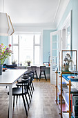 Dining room with pale blue walls in period apartment