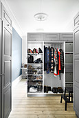 Half-open wardrobe with grey doors used as partition